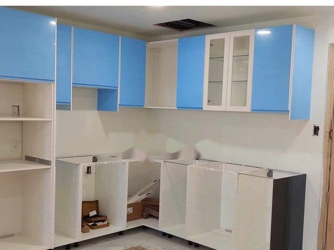New kitchen cabinetry installed in a stripped room, wall and base units set out and levelled