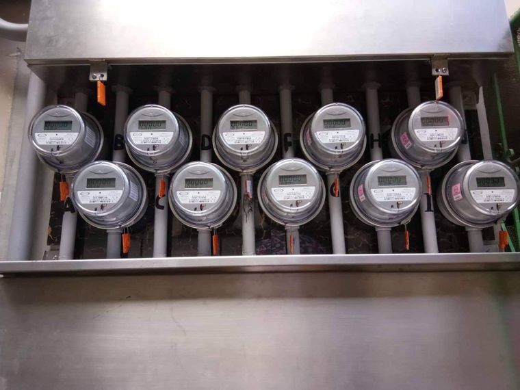 Bank of ten utility electricity meters in a stainless steel enclosure