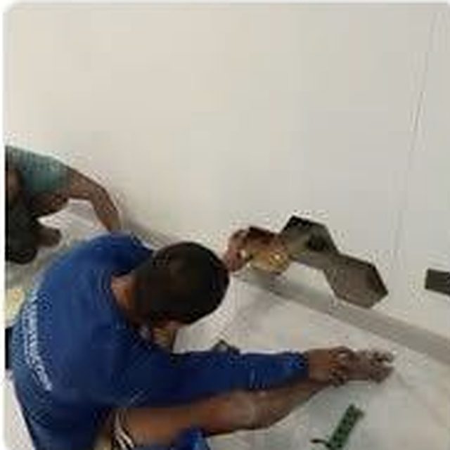 Tiler setting hexagonal wall tiles during an interior fit-out